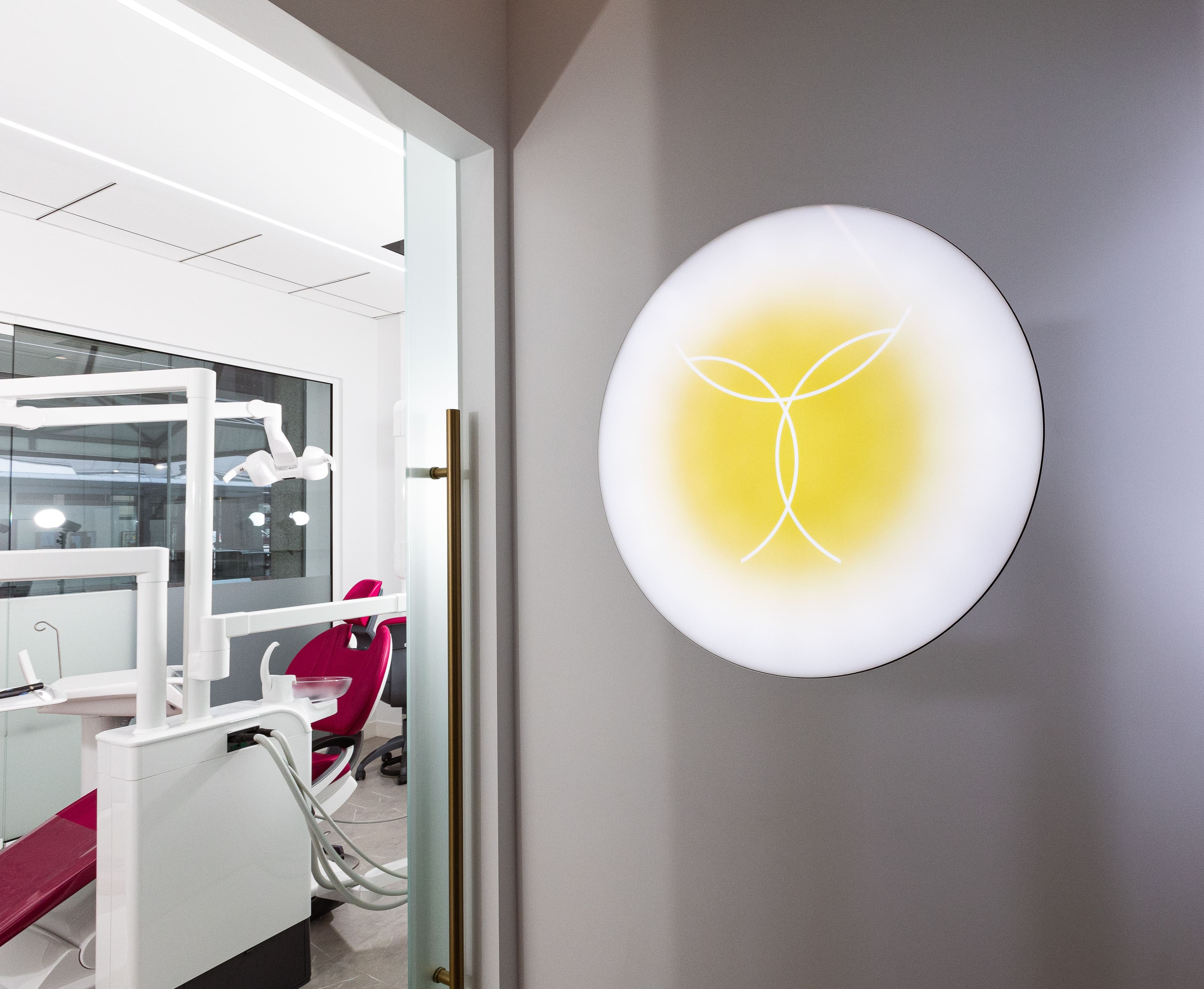Transcend Dentistry branded hallway with illuminated logo — specialist dental office Vancouver